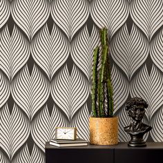 a potted plant sitting on top of a table next to a wallpapered wall