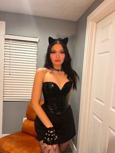 a woman in a black corset and cat ears is posing for the camera