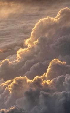 an airplane is flying high in the sky with clouds around it and sun shining through