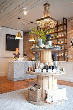 a woman is sitting at the counter in a beauty salon with lots of products on display