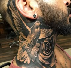 a man with a bird and flower tattoo on his neck