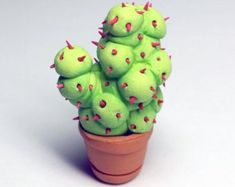 a small green cactus plant with spikes on it's head in a clay pot