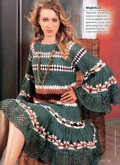 a woman sitting in a chair wearing a green dress