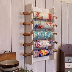 a wall mounted spice rack with six rolled up napkins