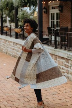 a woman is walking down the street wearing a blanket