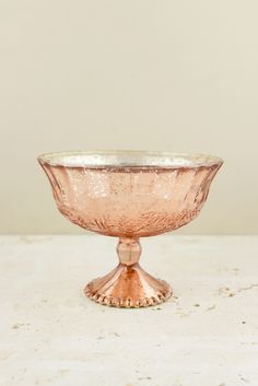 a pink glass bowl sitting on top of a table