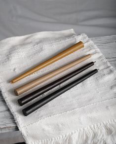 three different types of pens sitting on top of a white towel