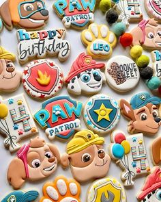 some decorated cookies are laying out on a white surface with the words paw patrol written on them