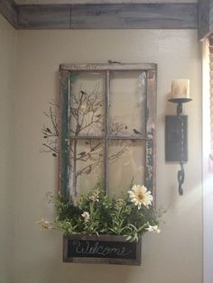 an old window is decorated with flowers and greenery as well as a sign that says welcome