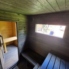 the inside of a wooden sauna with benches and a bench in front of it