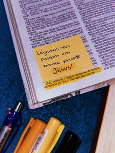 an open bible with writing on it next to some crayons