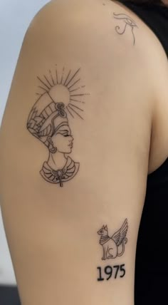 the back of a woman's shoulder with tattoos on her left arm and an egyptian head