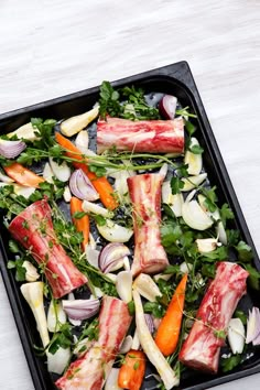 a tray filled with meat and vegetables on top of a table