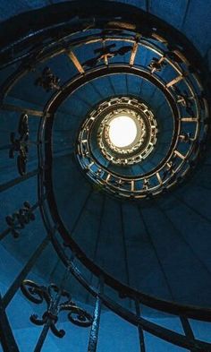 a spiral staircase in a building lit by a light bulb