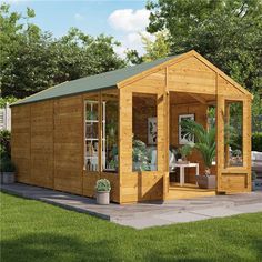 a small wooden shed sitting on top of a lush green field