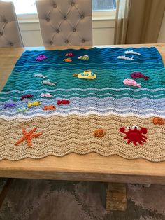 a crocheted table runner with sea animals on it