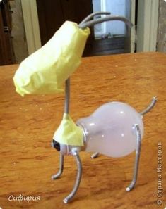 a plastic banana sitting on top of a wooden table next to a glass vase filled with liquid