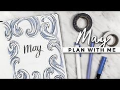 the may plan with me is next to some pens and scissors on a marble surface