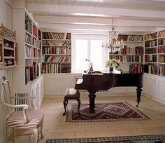 a living room filled with lots of furniture and bookshelves next to a piano