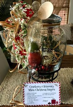 a glass jar filled with assorted items on top of a wooden table next to a sign