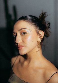 a woman with makeup on her face posing for the camera