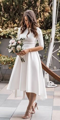 a woman in a white dress holding flowers