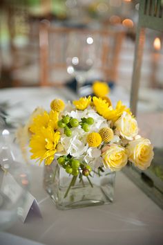 a vase filled with yellow and white flowers