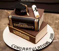 graduation cake made to look like two books with mortars on top and the words civil engineering written in gold