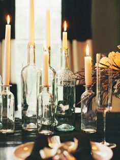 there are many candles and bottles on the table