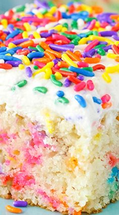 a piece of cake with white frosting and sprinkles