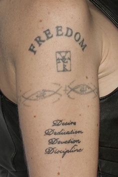 a woman with a tattoo on her arm that reads freedom and the words desolation