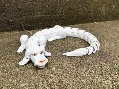 a white dragon head laying on the ground