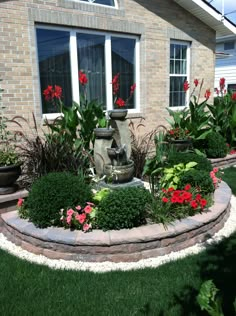 a garden with flowers and plants in front of a house