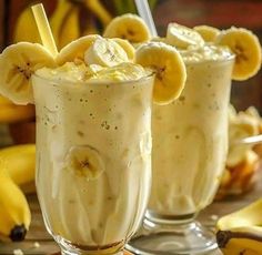 two glasses filled with ice cream and banana slices on top of each other next to bananas