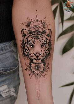 a black and white tiger with flowers on its head is shown in this tattoo design