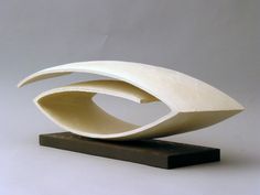 a white sculpture sitting on top of a wooden stand