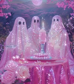 three ghostlyly dressed women sit at a table with a cake and candles in front of them