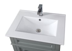 a white bathroom sink sitting under a faucet