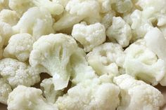 cauliflower florets sitting in a white bowl