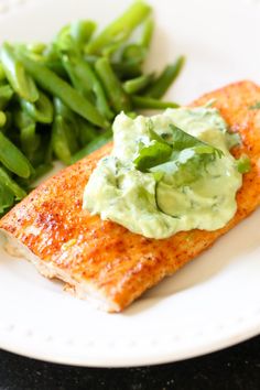 a white plate topped with fish and green beans