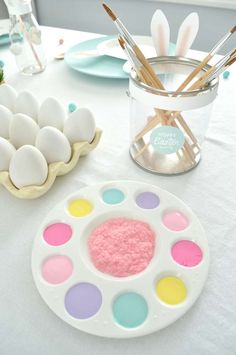 an easter table setting with painted eggs and utensils