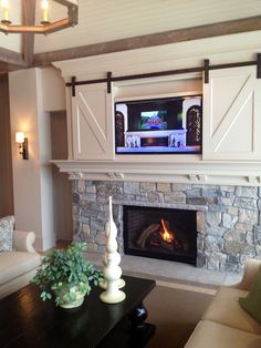 a living room with a fire place and television on the fireplace mantel above it