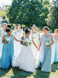 a group of women standing next to each other holding hands