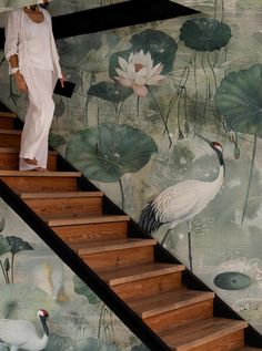 a woman walking up some stairs next to a mural