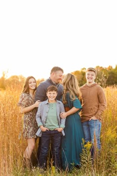 a family posing for a photo in the tall grass