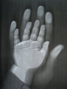 a person's hand in front of a black and white background with the image of an outstretched hand