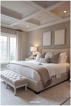 a large white bed sitting in a bedroom next to a window with two framed pictures on the wall