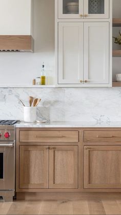 a kitchen with white marble counter tops and wooden cabinets, along with stainless steel appliances