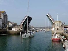 the boats are in the water by the bridge