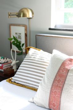 a bed with white and pink pillows on top of it